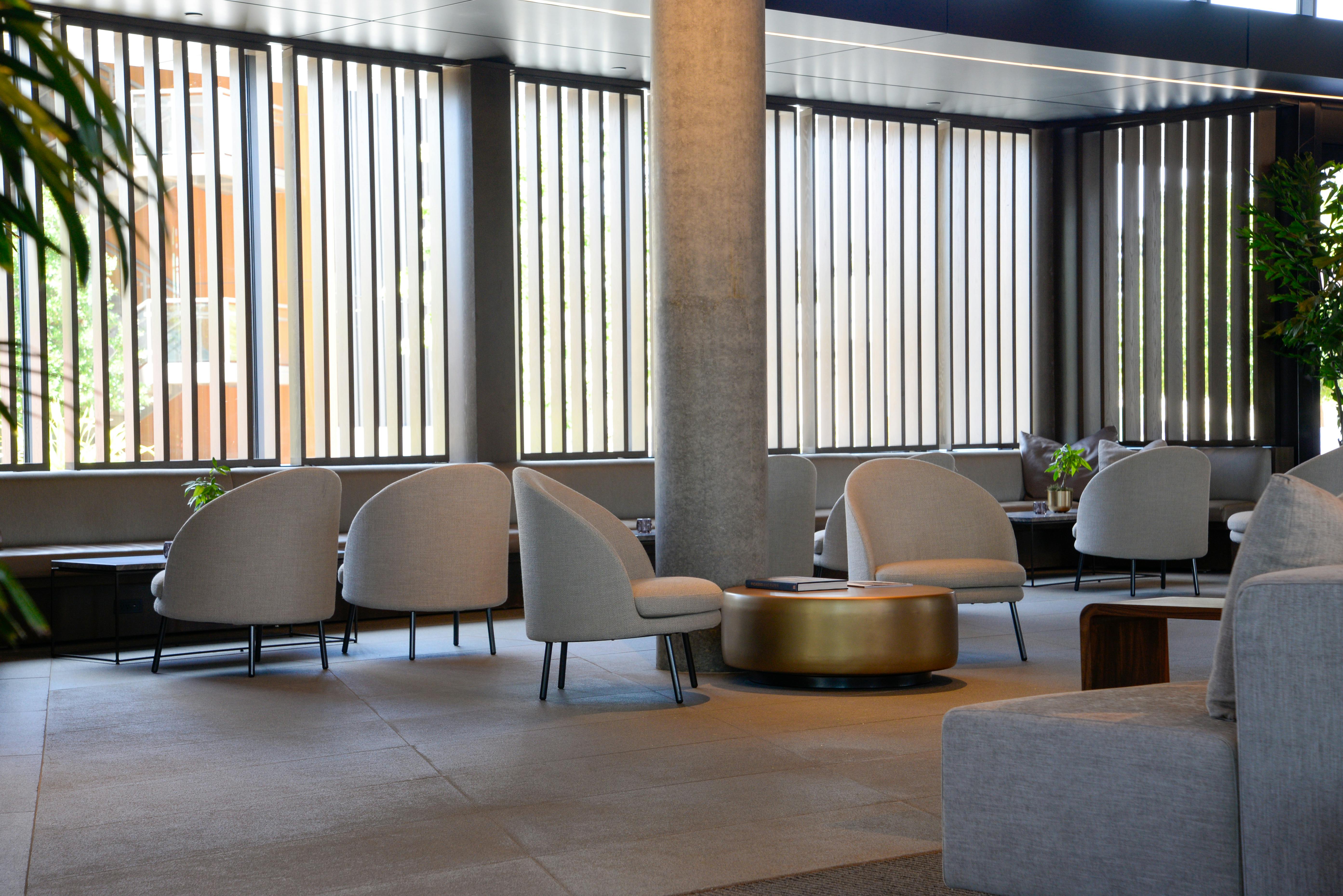 Daylit hotel lounge with quiet seating groups and editorial calm