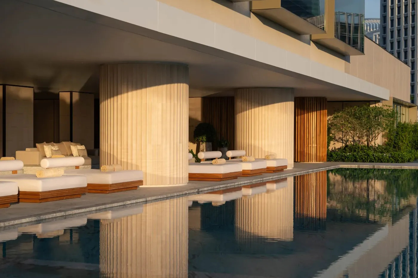Outdoor pool at Dusit Thani Bangkok framed by greenery and city towers